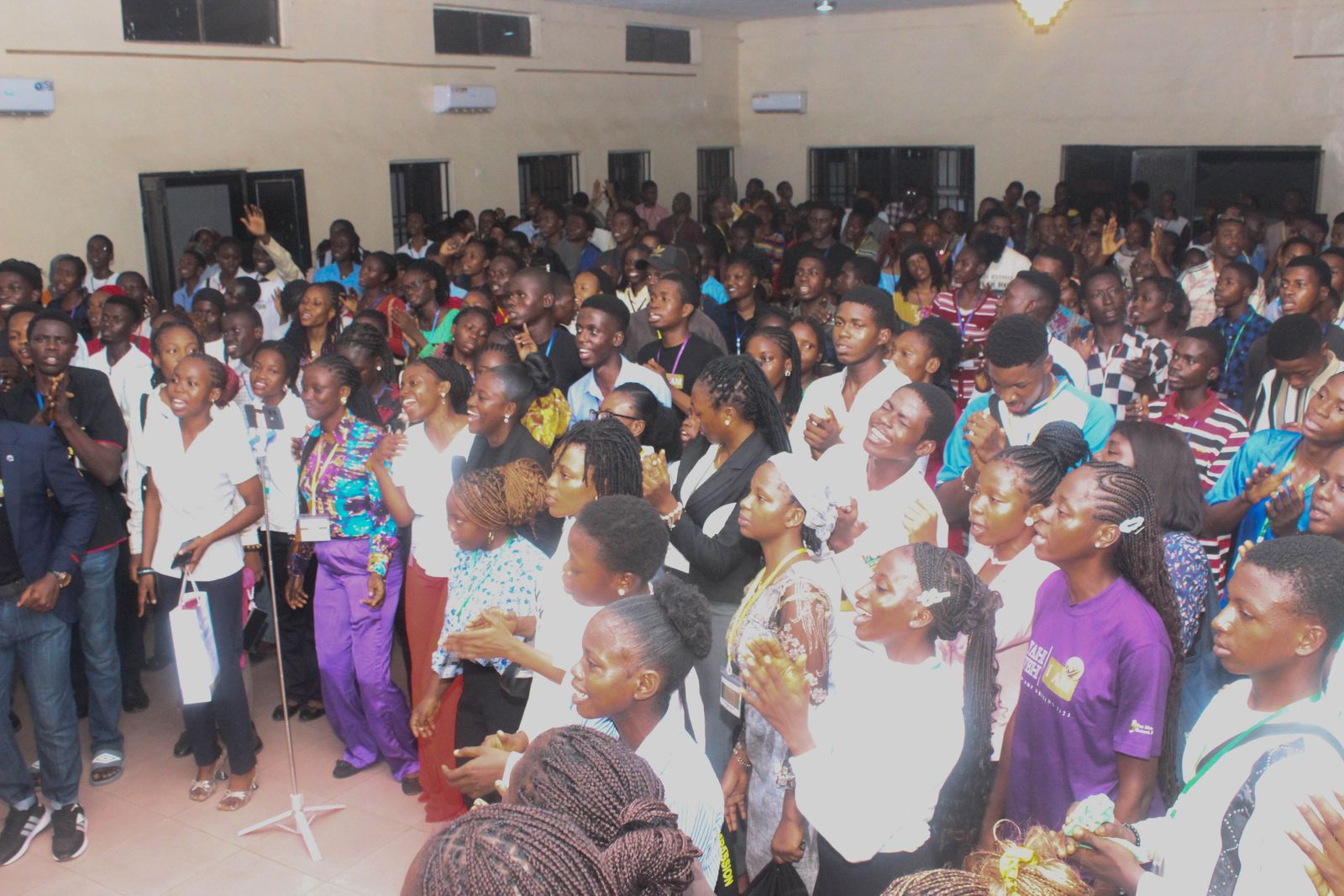A packed hall of young people worshipping together