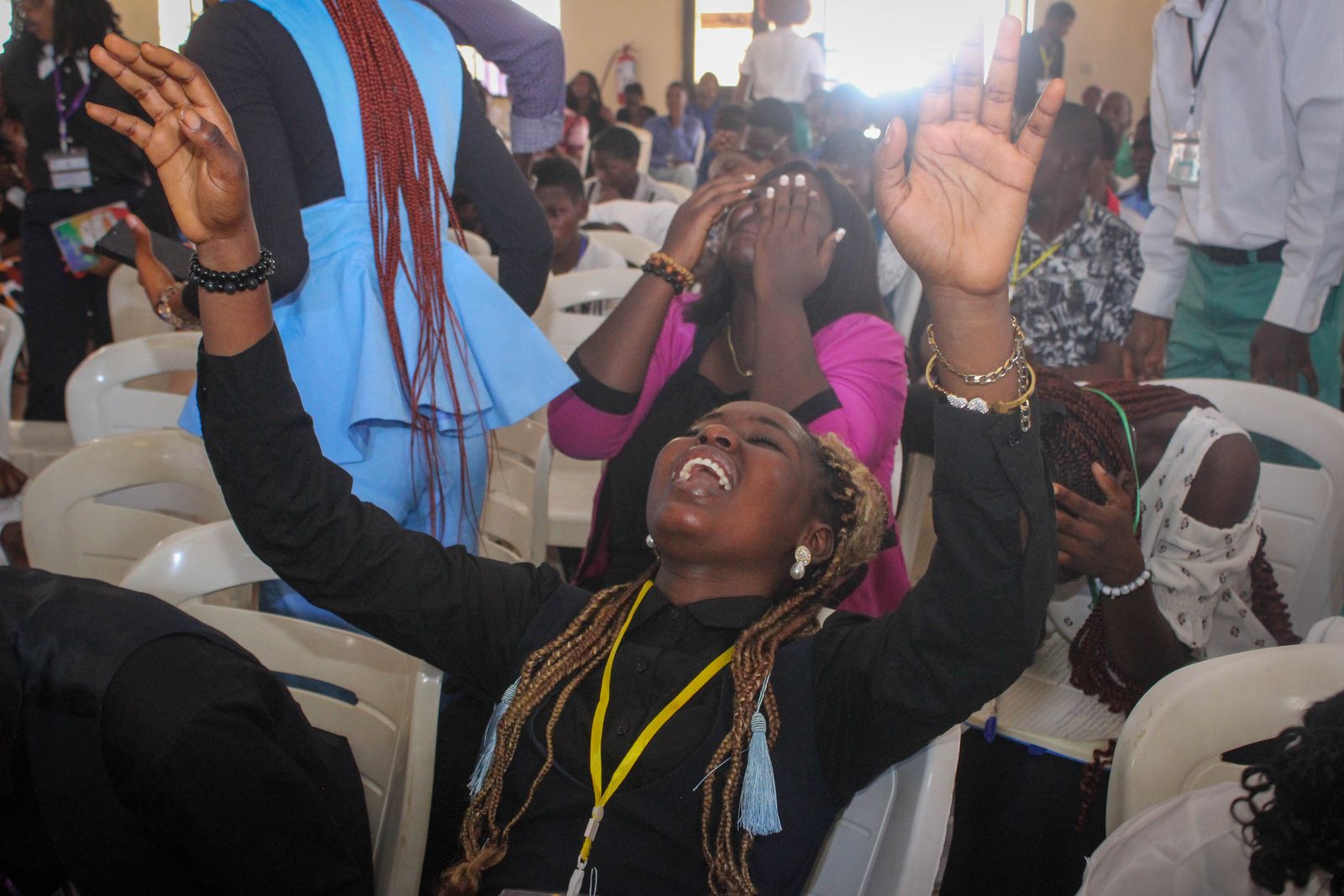 An attendee praising with both hands raised
