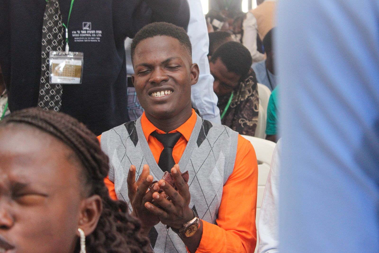 A young man clapping and worshipping in his seat