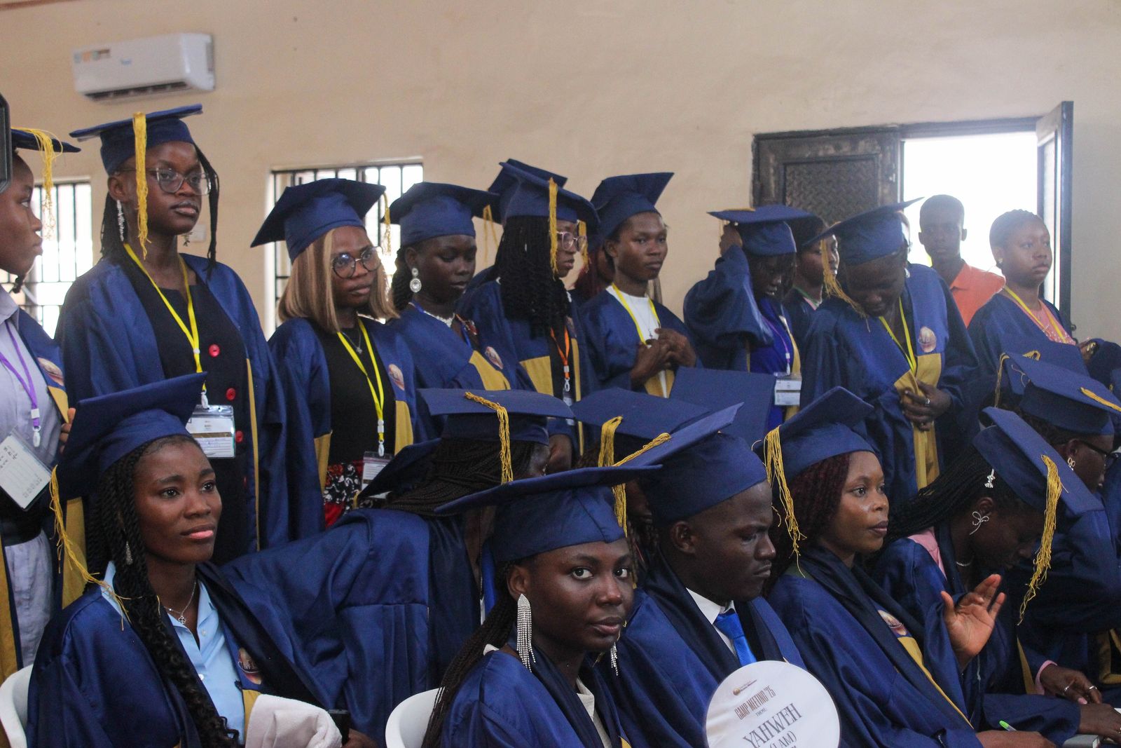 Graduates seated together in blue gowns and caps