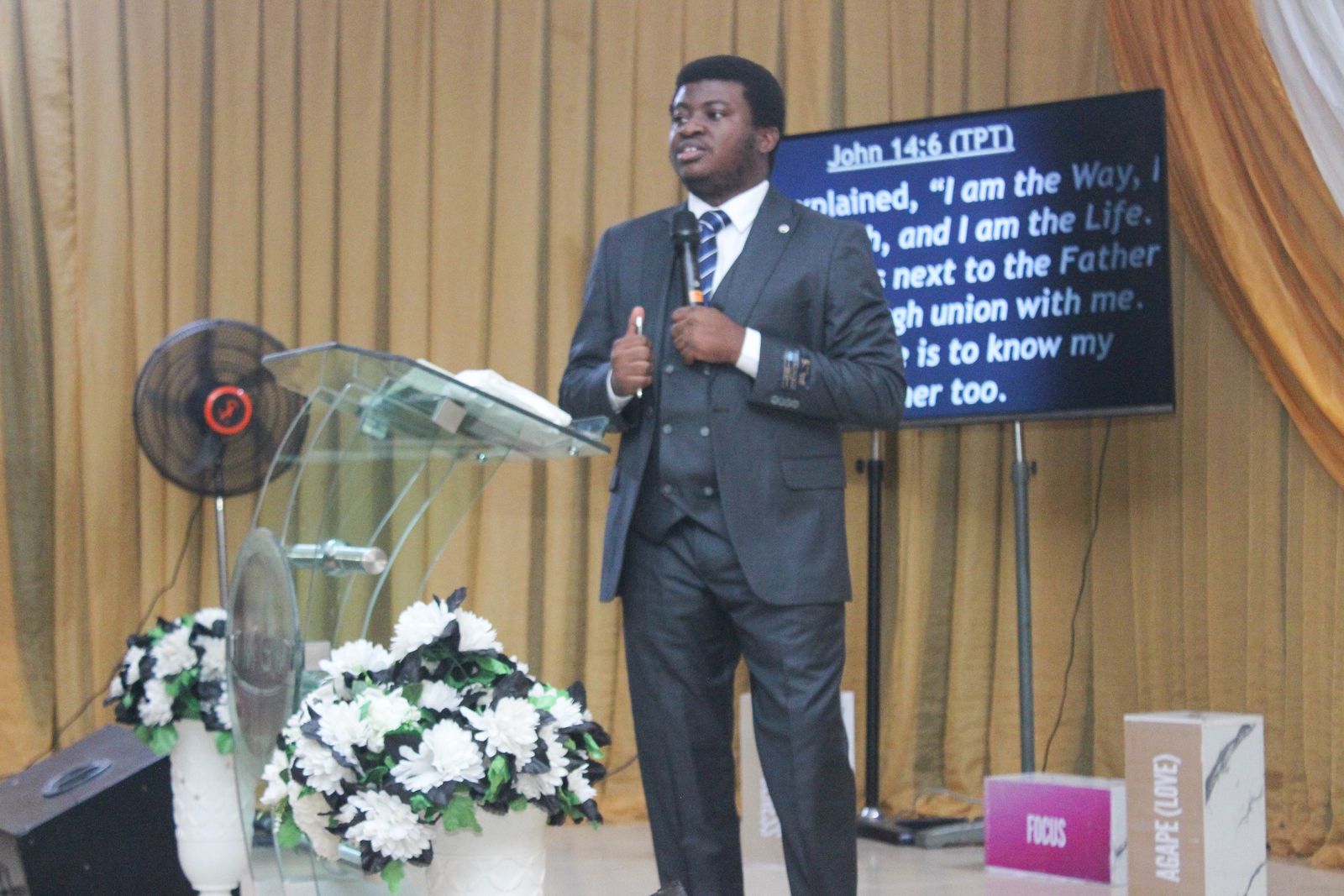 A minister teaching with John 14:6 on the screen behind him