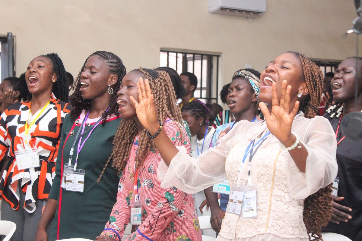 Young women worshipping with their hands raised
